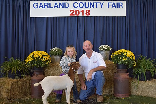 Submitted photo GRAND CHAMPION MARKET GOAT: The goat of Willa Grace Whiley, left, was named Grand Champion Market Goat. With her is the buyer, state Rep. Bruce Cozart. Buckle Sponsor was Razorback Camper Sales.