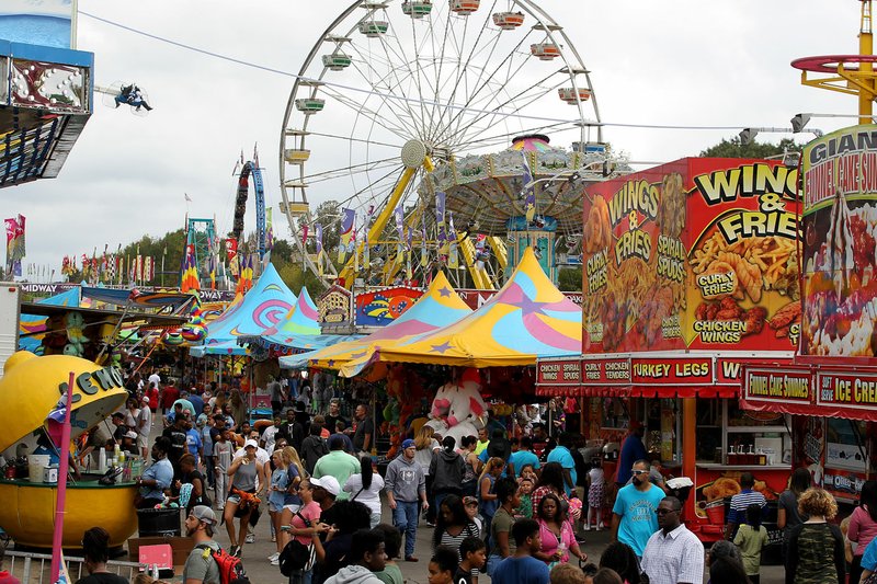 File Photo/THOMAS METTHE Fairgoers enjoy the midway at the 2017 Arkansas State Fair in Little Rock.