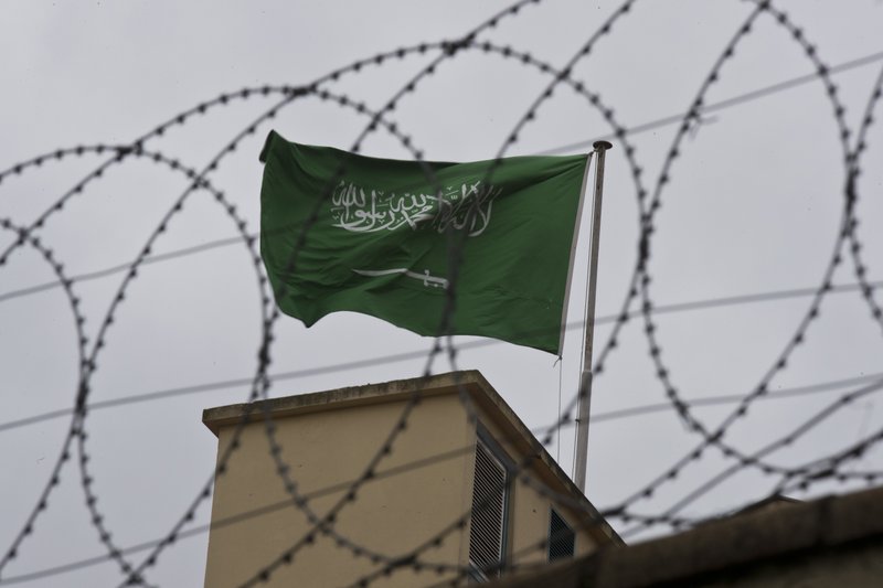 A flag of Saudi Arabia flies behind barb wire, on the roof top of Saudi Arabia's consulate in Istanbul, Saturday, Oct. 13, 2018. Turkish officials have an audio recording of the alleged killing of journalist Jamal Khashoggi from the Apple Watch he wore when he walked into the Saudi Consulate in Istanbul over a week ago, a pro-government Turkish newspaper reported Saturday. (AP Photo/Petros Giannakouris)