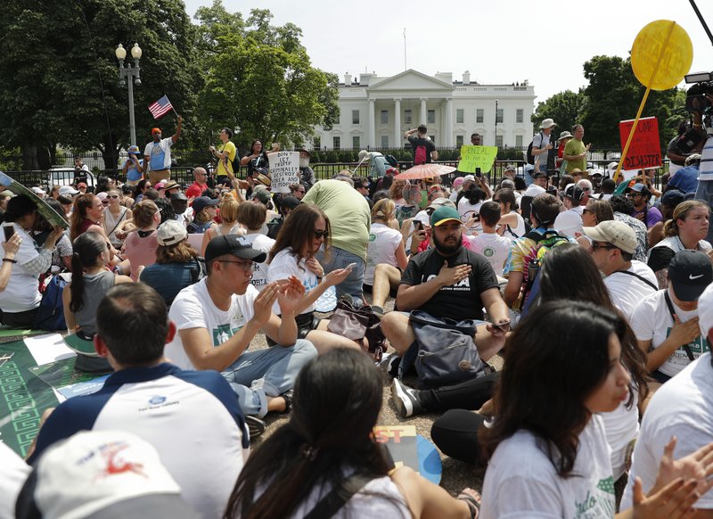 In this April 29, 2017, file photo, demonstrators sit on the ground along Pennsylvania Ave. in front of the White House in Washington. The National Park Service is exploring the question of whether it should recoup from protest organizers the cost of providing law enforcement and other support services for demonstrations held in the nation's capital.  (AP Photo/Pablo Martinez Monsivais, File)