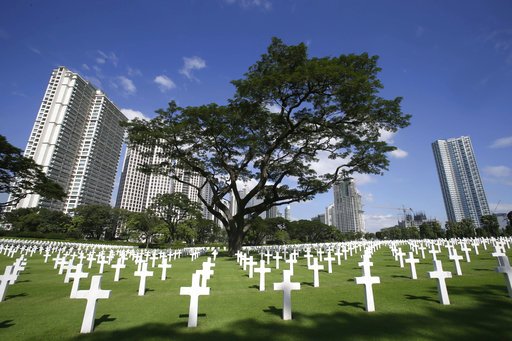  In this Nov. 11, 2012, file photo, rows of crosses totaling 16,933 Latin crosses, 164 Stars of David and 3,740 unknowns, dot the 152-acre American Cemetery on U.S. Veterans Day at the American Cemetery at suburban Taguig city, east of Manila, Philippines. The body of the former journalist and U.S. Marine spent decades in an unknown soldier grave in Manila American Cemetery.  (AP Photo/Bullit Marquez, File)