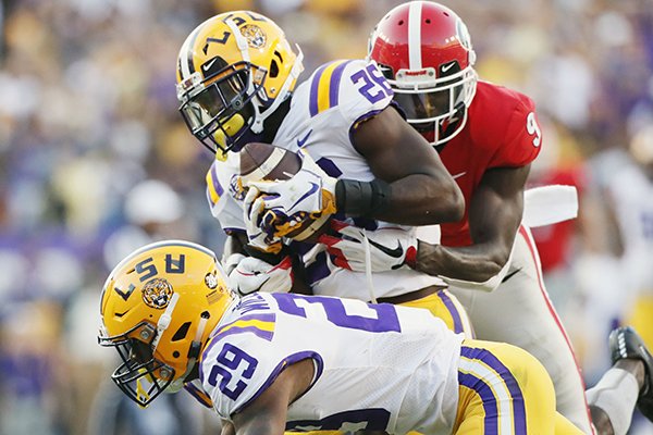LSU safety John Battle (26), with assistance from cornerback Greedy Williams (29), intercepts a pass from Georgia quarterback Jake Fromm intended for wide receiver Jeremiah Holloman, rear, during the fourth quarter of an NCAA college football game Saturday, Oct. 13, 2018, in Baton Rouge, La. (Bob Andres/Atlanta Journal Constitution via AP)

