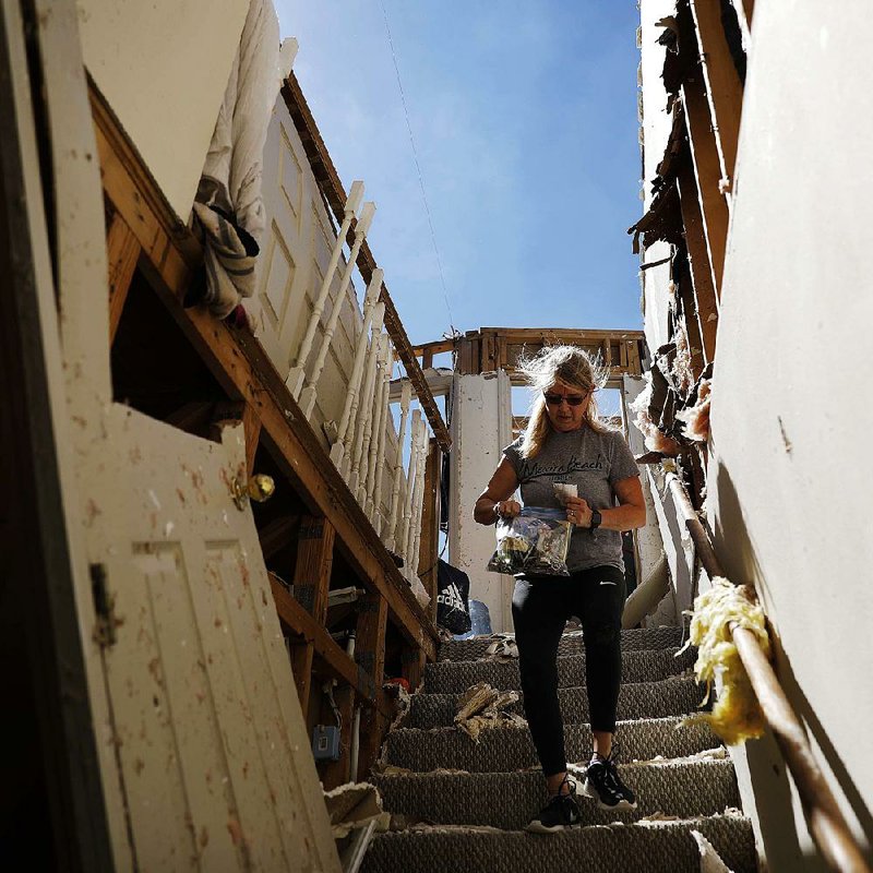 Candace Phillips retrieves personal items from her damaged home Sunday in Mexico Beach, Fla., in the aftermath of Hurricane Michael. 