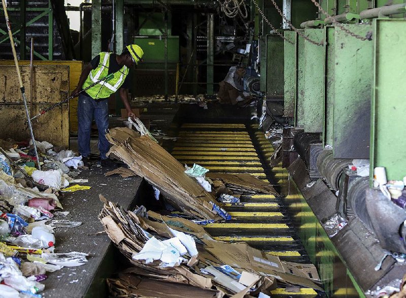 FILE — Steven Manning, a quality-control technician, sorts contaminants from cardboard being bundled at the Waste Management recycling facility in Little Rock in this Oct. 14, 2018 file photo. 