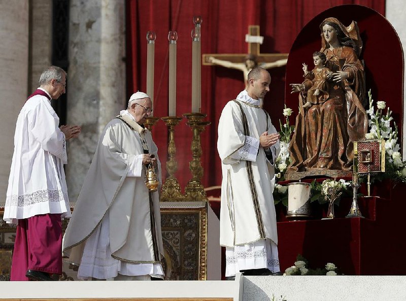 Pope Francis (center) conducts a canonization ceremony in St. Peter’s Square on Sunday at the Vatican. 