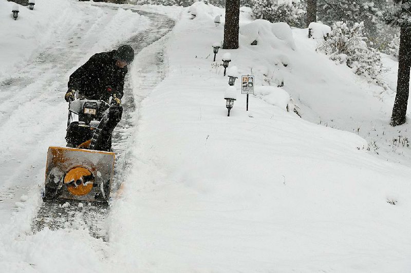 Scott Henderson plows his driveway Sunday, in Nederland, Colo. Nederland got over 10 inches of snow in this fall storm. 