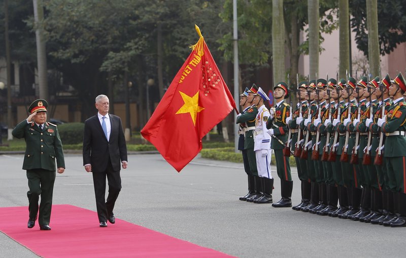 FILE - In this Jan. 25, 2018, file photo, U.S. Defense Secretary Jim Mattis and his Vietnamese counterpart Ngo Xuan Lich, left, review an honor guard in Hanoi, Vietnam. By making a rare second trip this year to Vietnam, Mattis is showing how intensively the Trump administration is trying to counter China&#x2019;s military assertiveness by cozying up to smaller nations in the region who share American wariness about Chinese intentions. The visit beginning Tuesday also shows how far U.S.-Vietnamese relations have advanced since the tumultuous years of the Vietnam War, whose legacy includes a continued search for the remains of U.S. war dead on Vietnamese soil. (AP Photo/Tran Van Minh, File)