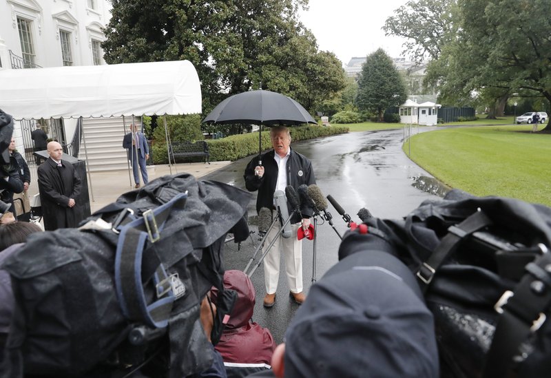 President Donald Trump stops to talk to members of the media before walking across the South Lawn of the White House in Washington, Monday, Oct. 15, 2018, to board Marine One helicopter for a short trip to Andrews Air Force Base, Md., en route to Florida to tour areas the devastation left behind from Hurricane Michael last week. (AP Photo/Pablo Martinez Monsivais)


