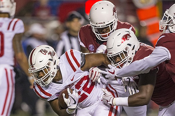 Arkansas defenders attempt to tackle Ole Miss running back Scottie Phillips during a game Saturday, Oct. 13, 2018, in Little Rock. 