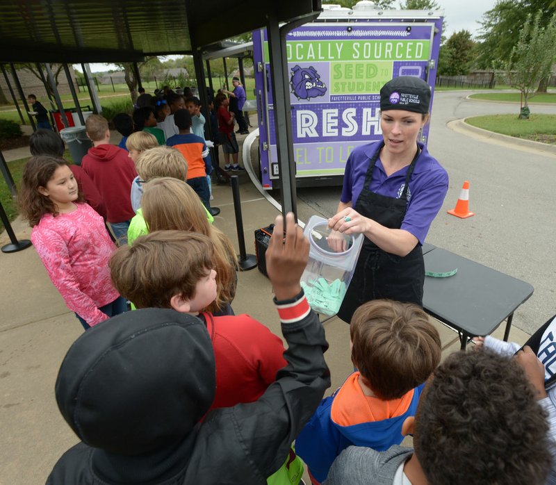 NWA Democrat-Gazette/ANDY SHUPE Ally Mrachek, director of the child nutrition department for Fayetteville Public Schools, greets fifth-grade students Wednesday before serving a hot lunch from the district food truck at Holt Middle School in Fayetteville. The food truck made its first stop in a tour of Fayetteville Public School's secondary schools in the Food Truck Dayz lunch series to raise awareness for the truck and the service it provides to promote healthy eating habits and offer meals to students in need.