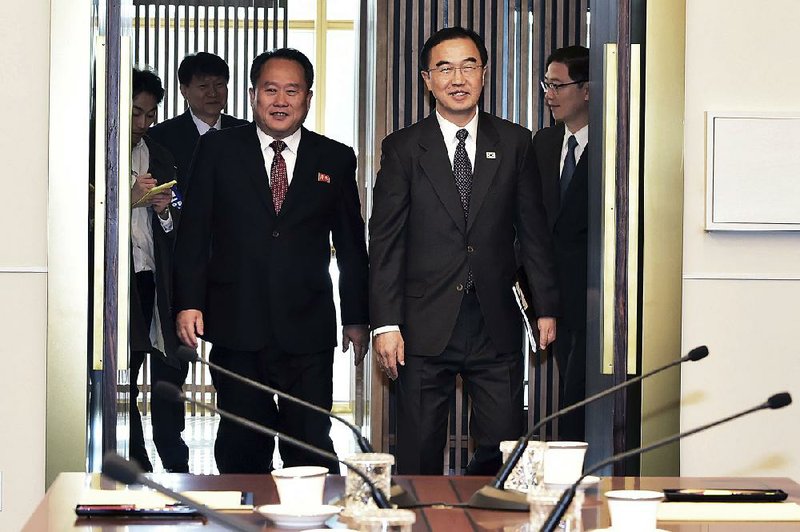 South Korean Unification Minister Cho Myoung-gyon (right) and North Korean counterpart Ri Son Gwon arrive for a meeting Monday on the south side of the Panmunjom border village in the Demilitarized Zone.