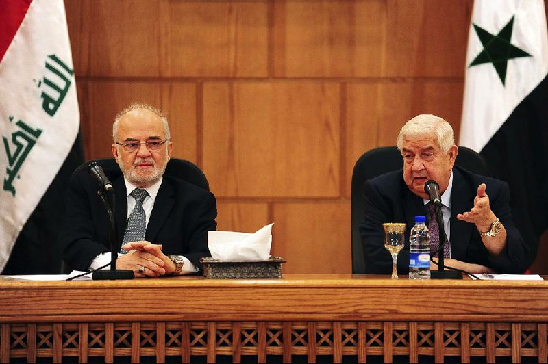 Syrian Foreign Minister Walid al-Moallem (right) and Iraqi counterpart Ibrahim al-Jaafari hold a news conference Monday during al-Jaafari’s visit to Damascus. Syria is working to renew ties with its neighbors after removing rebel forces from most of the country.