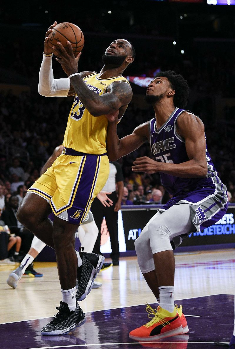 Los Angeles Lakers forward LeBron James goes up for a shot while Sacramento Kings forward Marvin Bagley III defends during the first half of a preseason game Thursday in Los Angeles. James signed a four-year deal with the Lakers in July and made the move from the Eastern Conference, where he spent his first 15 seasons in the league.