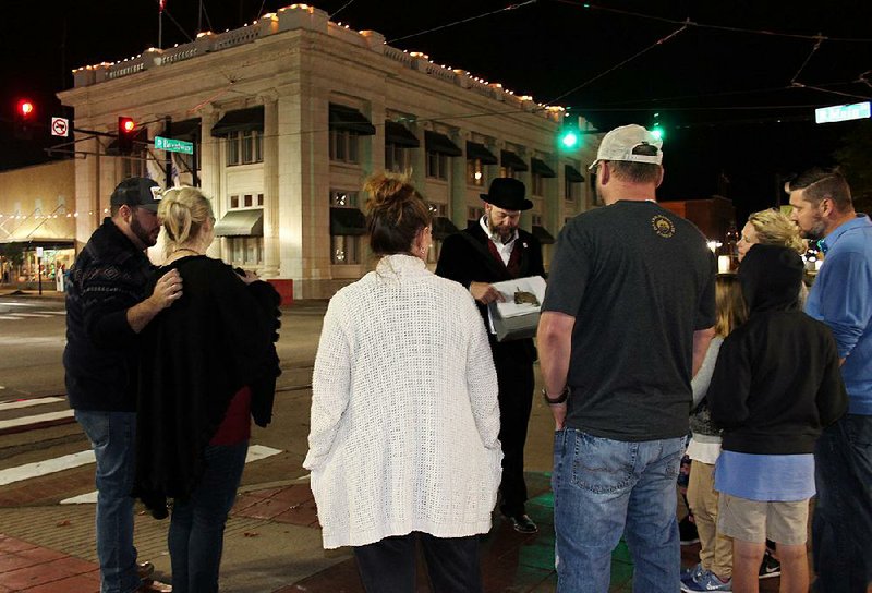 Paul Prater (center), points to a photo during a recent Haunted Argenta Ghost Tour in downtown North Little Rock. 