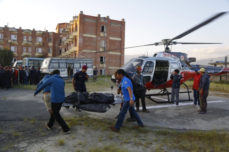 Officials unload the bodies after a helicopter carrying bodies of those killed in Gurja Himal mountain arrives at the Teaching hospital in Kathmandu, Nepal, Sunday, Oct. 14, 2018. Rescuers retrieved the bodies of five South Korean climbers and their four Nepalese guides from Gurja Himal mountain, where they were killed when their base camp was swept by a strong storm. (AP Photo/Niranjan Shrestha)