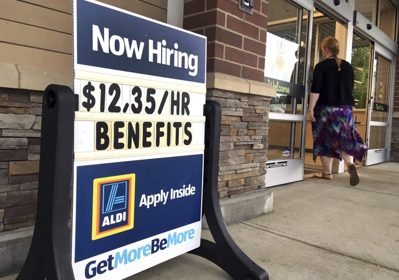 In this July 17 file photo, a sign outside a business in Salem, N.H. says "Now Hiring." On Tuesday, the Labor Department reports on job openings and labor turnover for August. (AP Photo/Elise Amendola, File)

