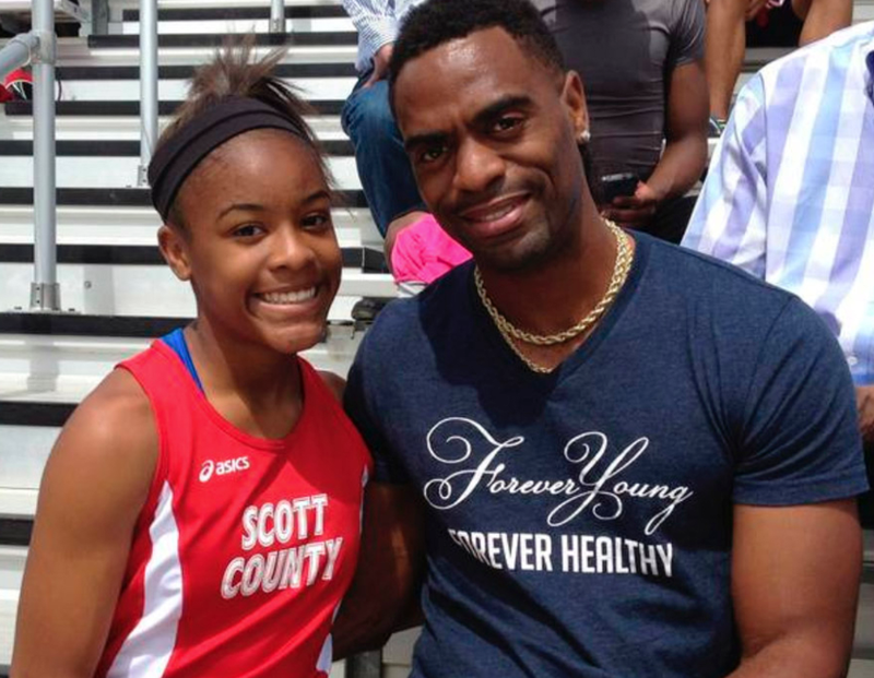 FILE - In this May 3, 2014, file photo, Trinity Gay, then a seventh-grader racing for her Scott County High School team, poses for a photo with her father, Tyson Gay, after she won the 100 meters and was part of the winning 4-by-100 and 4-by-200 relays at the meet in Georgetown, Ky