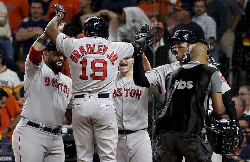 Jackie Bradley Jr. (19) of the Boston Red Sox celebrates with teammates after his grand slam in the eighth inning of Tuesday’s 8-2 victory over the Houston Astros in Game 3 of the American League Championship Series. Boston holds a 2-1 lead in the series.