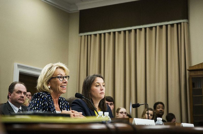Secretary of Education Betsy DeVos (left), shown speaking during a House subcommittee hearing in Washington last year, has lost her battle in federal court to scrap an Obama-era policy making it easier for students defrauded by for-profit colleges to get their student loans forgiven. 