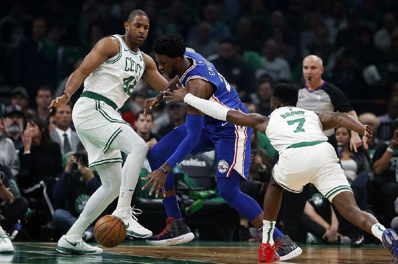 PAl Horford of the Boston Celtics (left) and Jaylen Brown (right) surround Joel Embiid of the Philadelphia 76ers in the Celtics’ 105-87 victory over the Philadelphia 76ers on Tuesday night. Embiid led the 76ers with 23 points, while Brown had 12 and Horford 9 for the Celtics. 
