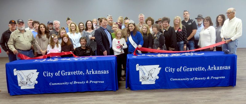 Westside Eagle Observer/SUSAN HOLLAND Members of the crowd are all smiles just after young Linnie Pipkin cuts the ribbon at the newly renovated Gravette Civic Center Thursday evening, Oct. 11. She was joined by Mayor Kurt Maddox, city officials and city council members and several members of the Greater Gravette Chamber of Commerce.