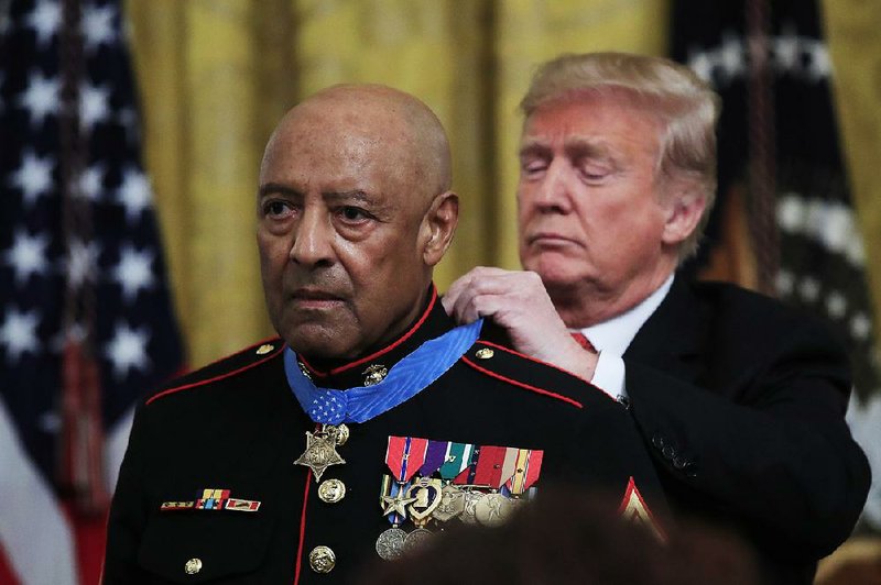 President Donald Trump presents the Medal of Honor to U.S. Marine Corps retired Sgt. Maj. John L. Canley in the East Room on Wednesday. 