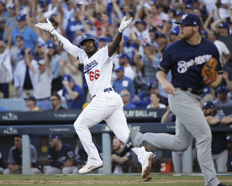 Yasiel Puig of the Los Angeles Dodgers celebrates after hitting an RBI single in the sixth inning of the Dodgers’ 5-2 victory over the Milwaukee Brewers on Wednesday in Game 5 of the National League Championship Series. The Dodgers took a 3-2 lead in the series. 