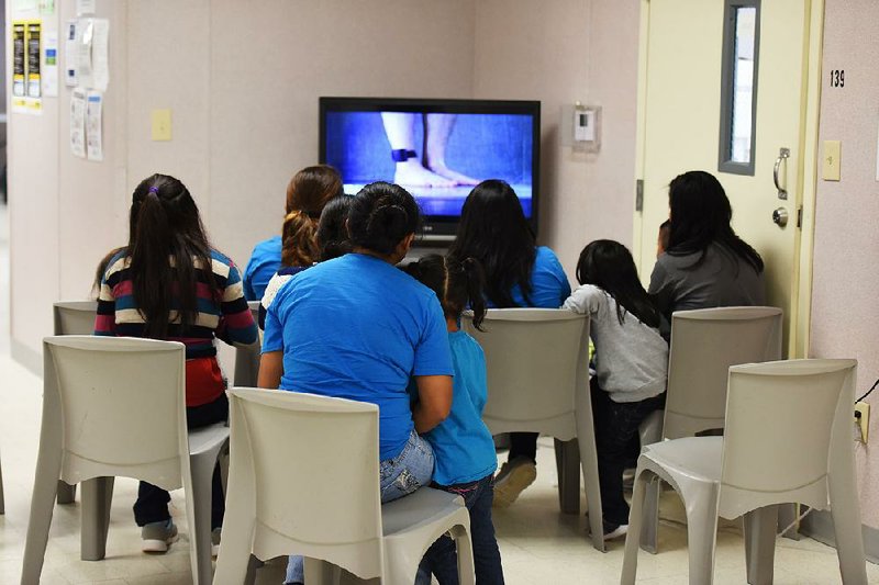 This photo provided by U.S. Immigration and Customs Enforcement shows people during an August tour of the South Texas Family Residential Center in Dilley, Texas. The 2,400-bed detention facility is being used to hold migrant mothers and children, under an arrangement with the U.S. government. 