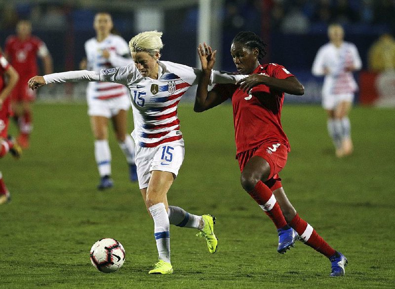 Forward Megan Rapinoe (15) of the United States and Canada’s Kadeisha Buchanan battle for possession of the ball Wednesday during the first half of the CONCACAF Women’s Championship final in Frisco, Texas. The United States won 2-0. 