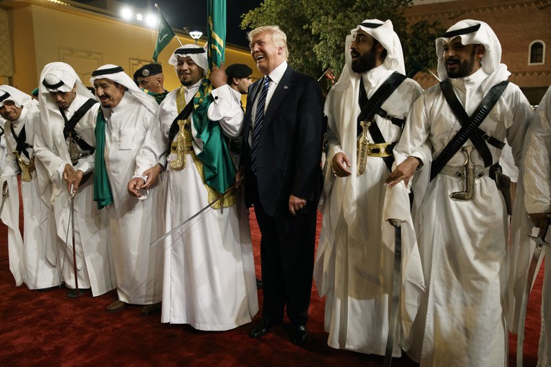 FILE - In this May 20, 2017 file photo, U.S. President Donald Trump holds a sword and dances with traditional dancers during a welcome ceremony at Murabba Palace, in Riyadh, Saudi Arabia. The Saudis are keen buyers of American weapons, using them in the Yemen War. The Trump administration says a proposed $110 billion deal would bolster the U.S. economy by creating tens of thousands of jobs and they do not want to risk that contract. But with Khashoggi feared dead, some want that transaction revisited. (AP Photo/Evan Vucci, File)