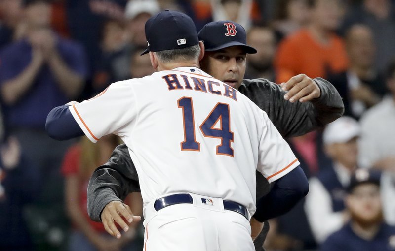 Houston Astros manager AJ Hinch, left, and Boston Red Sox manager Alex Cora hug before Game 3 of a baseball American League Championship Series on Tuesday, Oct. 16, 2018, in Houston. (AP Photo/David J. Phillip)