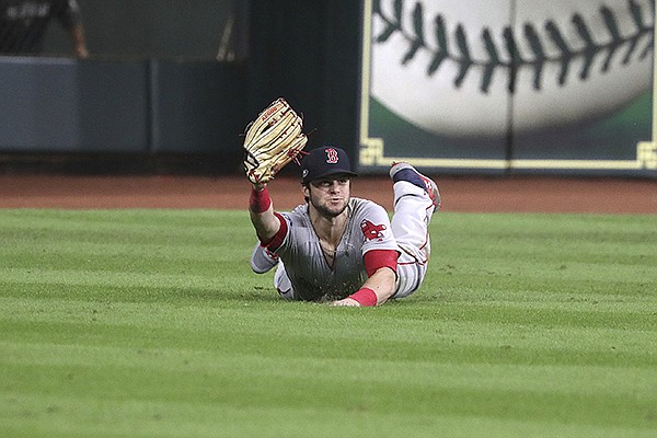 Boston Red Sox’ Andrew Benintendi makes a diving catch with the bases loaded for the final out of the ninth inning against the Houston Astros in Game 4 of the American League Championship Series, in Houston, Wednesday, Oct. 17, 2018. The Red Sox defeated the Astros 8-6 to take a 3-1 lead in the series. (Barry Chin/The Boston Globe via AP)

