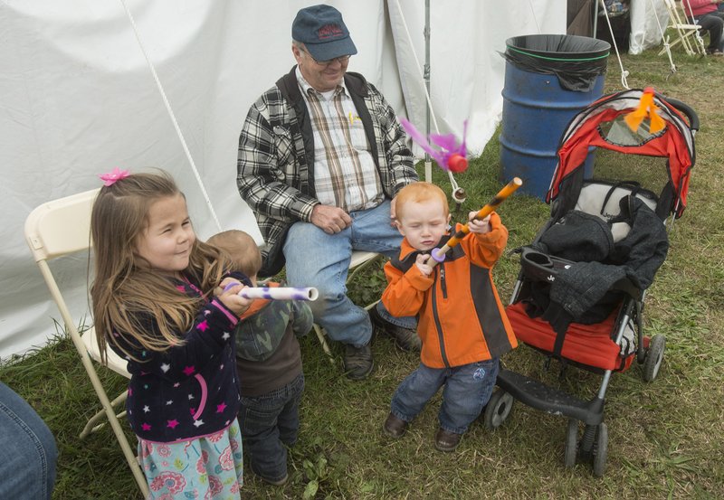 Rachel Call, 4, and cousins Andrew Call, 1, and Jacob Call, 3, play with their pop guns as grandfather Larry Call, all of Reeds Spring, Mo., looks on Thursday, Oct. 18, 2018, at the 50th annual Bella Vista Arts and Crafts Festival. 