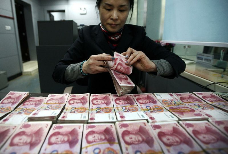 A clerk counts Chinese currency notes at a bank in Huaibei, China. The Chinese yuan slid Thursday to its lowest level in almost two years. 