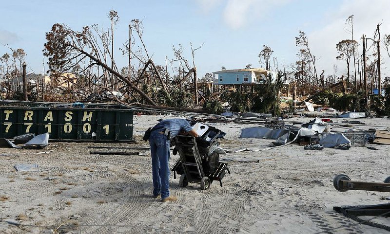 Robert Edmonson rests Wednesday after pulling a dolly through sand as he helps salvage belongings from his brother-in-law’s hurricane-destroyed home in Mexico Beach, Fla. 