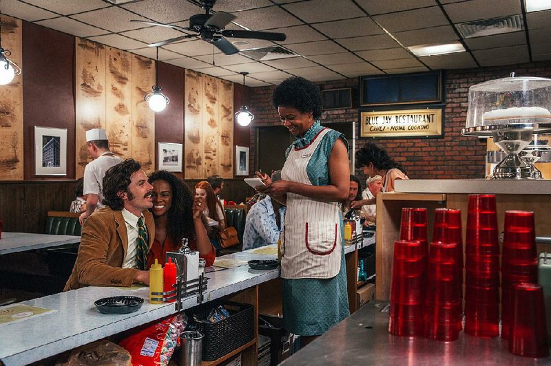 Police Detective John Hunt (Casey Affleck), shown ordering lunch with wife Maureen (Tika Sumpter), has mixed feelings about actually catching the crafty, venerable bank robber he’s chasing in The Old Man & the Gun.
