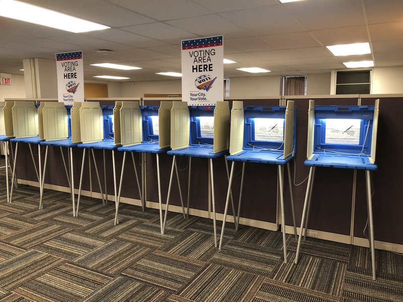 In this Sept. 20, 2018 photo, voting booths stand ready in downtown Minneapolis for the opening of early voting in Minnesota. Election officials and federal cybersecurity agents are touting improved collaboration aimed at confronting and deterring efforts to tamper with elections. Granted, the only way to go was up: In 2016 amid Russian meddling, federal officials were accused first of being too tight-lipped on intelligence about possible hacking into state systems, and later criticized for trying to hijack control from the states. The first test of this new-and-improved relationship could come on Nov. 6.  (AP Photo/Steve Karnowski)