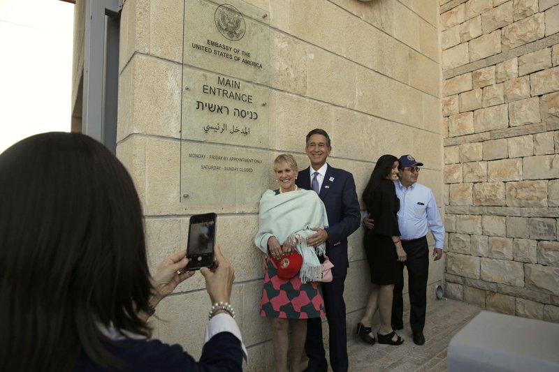 In this May 14, 2018 file photo, visitors have a photo taken at the entrance to the new U.S. Embassy in Jerusalem. The U.S. said Thursday Oct. 18, 2018 that it is placing its main diplomatic mission to the Palestinians under the authority of its embassy to Israel.  (AP Photo/Sebastian Scheiner, File)