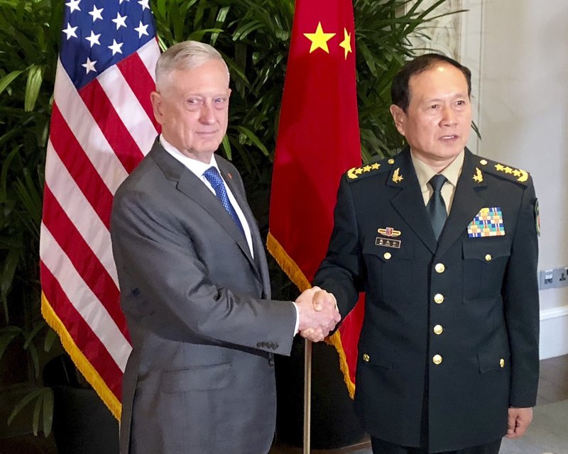 U.S. Defense Secretary Jim Mattis, left, meets Chinese Defense Minister Wei Fenghe in Singapore Thursday, Oct. 18, 2018. After a rocky few months, Pentagon officials say they sense that relations with the Chinese military may be stabilizing. (AP Photo/Robert Burns)