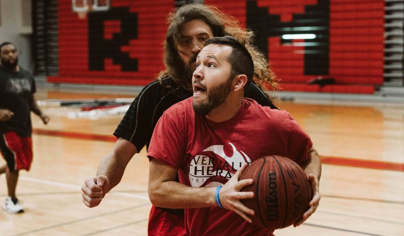 Gabe Harris (front) goes for a layup past guard Ryan Huelle during a pre-dawn pickup basketball game Oct. 1 at Russellville Middle School gym in Russellville. 
Special to the Democrat-Gazette/HEATH WHORTON