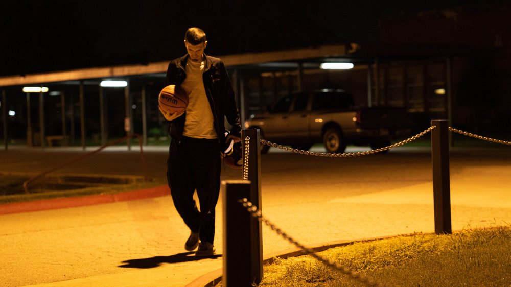 Basketball in hand, Eli Gunn, 34, walks through predawn darkness Oct. 1 to play a pickup game at the Clarksville High School gym with a group of men who have played together since the early 1990s, if not longer.  


Special to the Democrat-Gazette/JOSH WILSON
