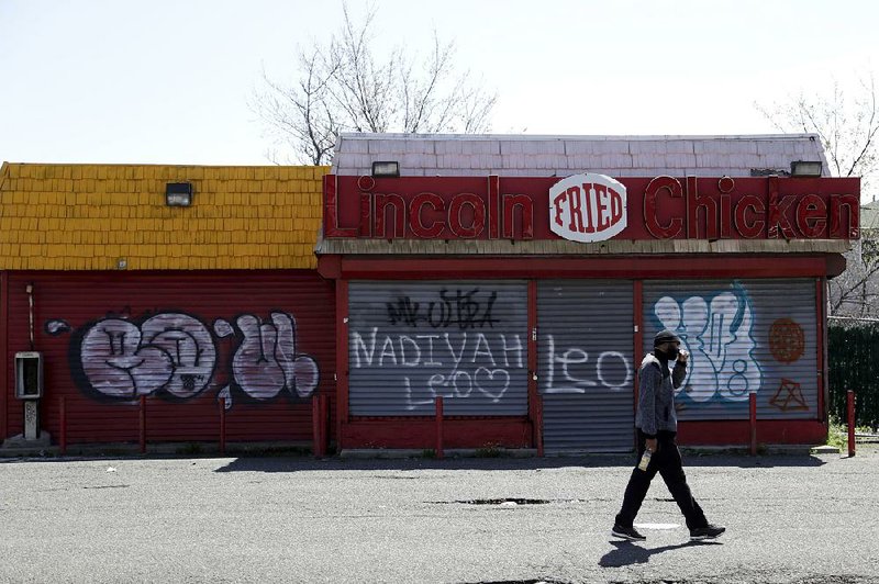 A man walks past a closed restaurant along Bergen Street in an economically depressed area of Newark, N.J., in April. About 8,700 such “opportunity zones” have been set up in 50 states.