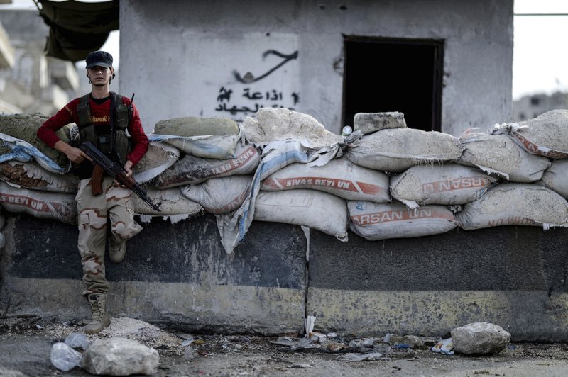 In this Oct. 13, 2018, file photo, a fighter of Syrian opposition stands at a checkpoint in northwestern city of Idlib, Syria. A Turkish official says Friday, Oct. 19, 2018, that a summit between the leaders of Turkey, France, Germany and Russia will be held in Istanbul this month to discuss the conflict in Syria. (Ugur Can/DHA via AP, File)