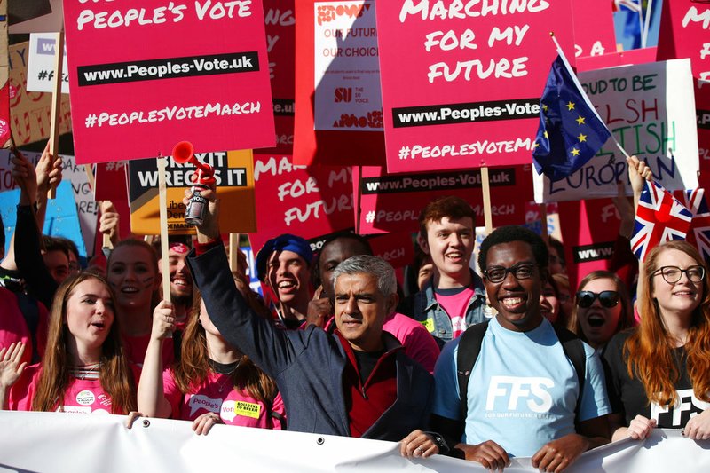 Mayor of London Sadiq Khan, front centre, holds a klaxon horn, as he joins protesters in the People's Vote March for the Future, in London, Saturday Oct. 20, 2018. Some thousands of protesters are marching through central London, Saturday, to demand a new referendum on Britain's Brexit departure from the European Union. (Yui Mok/PA via AP)