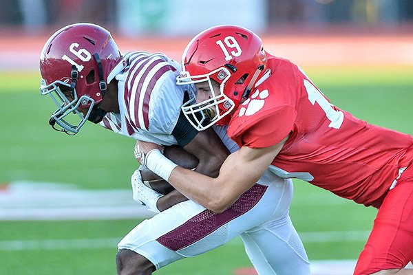 Pine Bluff receiver Isiah Mays (16) is tackled by Cabot safety Zhane Harper during a game Friday, Aug. 31, 2018, at Panther stadium in Cabot.
