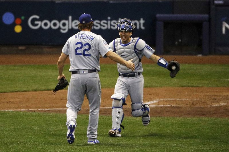 Los Angeles Dodgers catcher Austin Barnes rushes out to celebrate with pitcher Clayton Kershaw after the Dodgers’ victory over the Milwaukee Brewers in Game 7 of the National League Championship Series on Saturday night. The Dodgers will face the Boston Red Sox in the World Series. Game 1 is Tuesday.