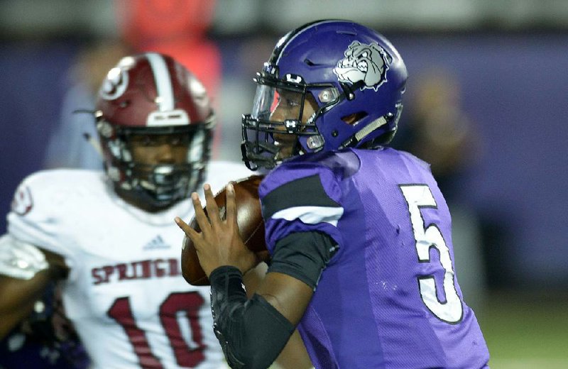 Fayetteville quarterback Darius Bowers looks to pass under pressure from Springdale linebacker
Chops Sanders on Friday at Harmon Stadium in Fayetteville. Fayetteville won 48-14.