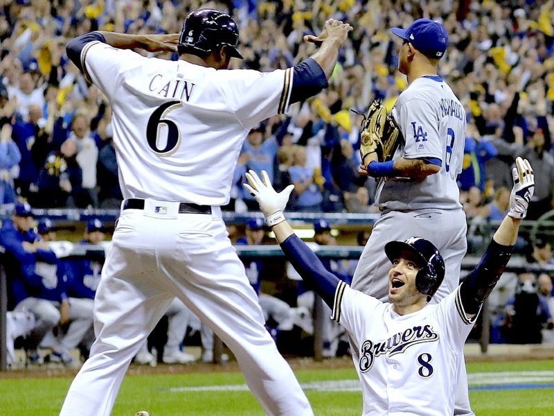 Milwaukee Brewers' Ryan Braun celebgrates with Lorenzo Cain after scoring on a double by Jesus Aguilar during the first inning of Game 6 of the National League Championship Series baseball game against the Los Angeles Dodgers Friday, Oct. 19, 2018, in Milwaukee. (AP Photo/Matt Slocum)