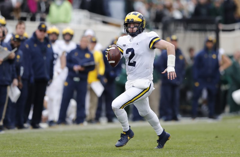 Michigan quarterback Shea Patterson scrambles during the first half of an NCAA college football game against Michigan State, Saturday, Oct. 20, 2018, in East Lansing, Mich. (AP Photo/Carlos Osorio)
