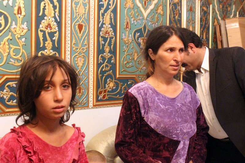 This photo released by the Syrian official news agency SANA shows Abeer Shalgheen, right, and one of her four children after being freed by the Islamic State group that kidnapped them on July 25 during a raid by the extremists on the southern province of Sweida, Syria, Saturday, Oct. 20, 2018. The Islamic State group early Saturday released two women and four children they had been holding since July in the first part of an exchange with the Syrian government that will set free dozens of women related to members of the extremist group, opposition activists said. (SANA via AP)